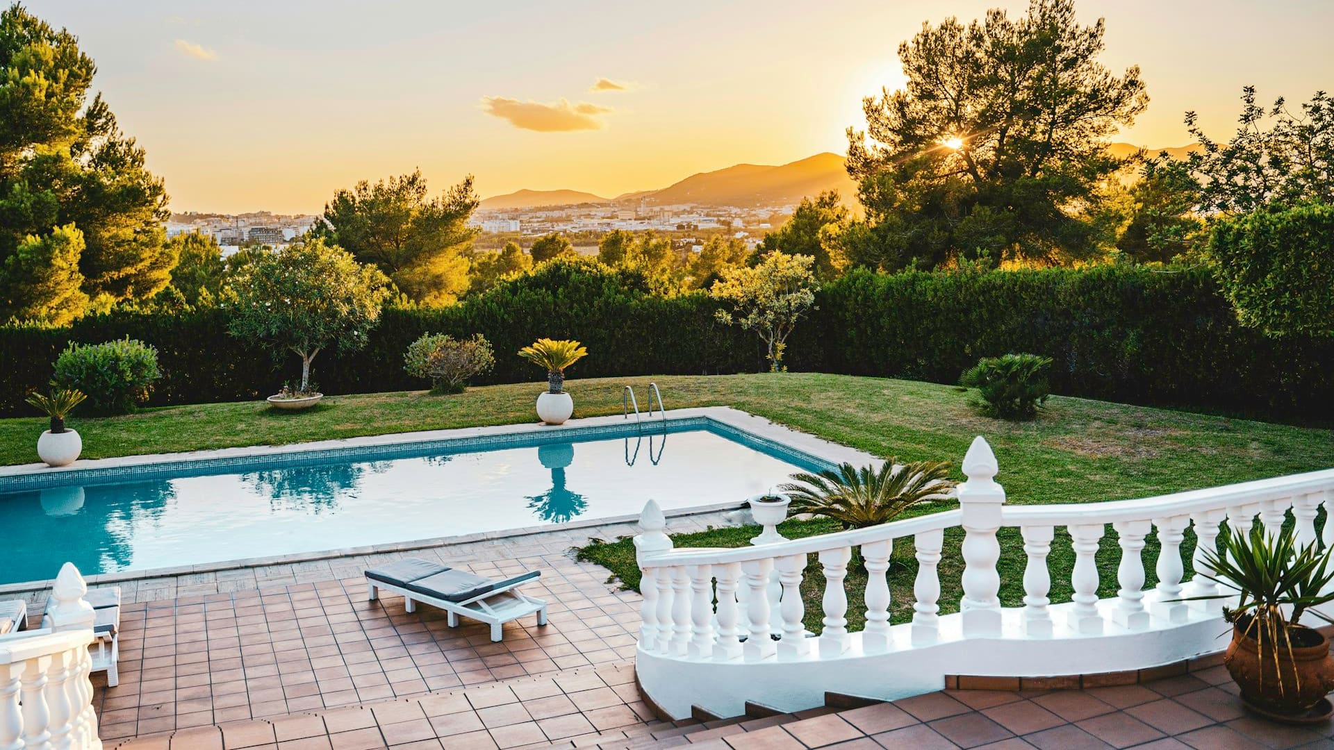 İzmir kıyısında golden-hour ışıkta zeytin, lavanta ve servilerle düzenlenmiş premium villa bahçesi, atmosferik temsilî görsel