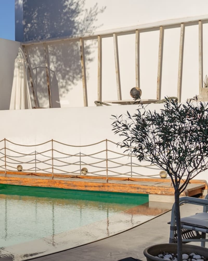 Urla zeytinlik villa bahçesi, golden-hour ışıkta zeytin ağaçları ve düzenli Akdeniz bitkilendirmesi